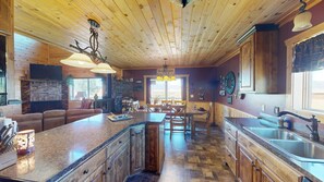 Full size kitchen with basic appliances, stove, fridge, microwave, and dishes.