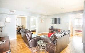 The living area boasts two comfortable leather sofas and a flat screen TV.