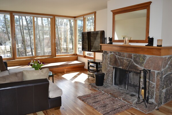 Living room with 55 inch HDTV, natural fireplace and plenty of natural lighting.
