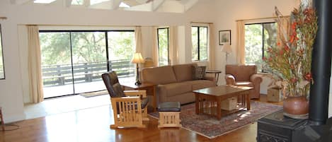 Living Room with cathedral ceilings and expansive deck and views.