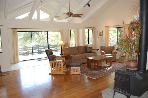 Living Room with cathedral ceilings and expansive deck and views.