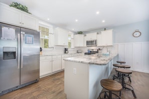 Open concept kitchen with granite countertops and stainless appliances. 