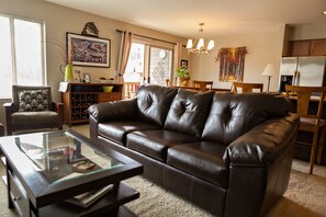 The living room which is surrounded by windows with lots of light and views