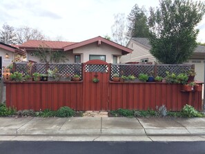 The street view of the apartment with the fenced patio  