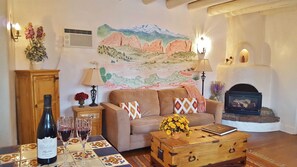 Sitting room with ceiling vigas, original hardwood floors; view towards mountain