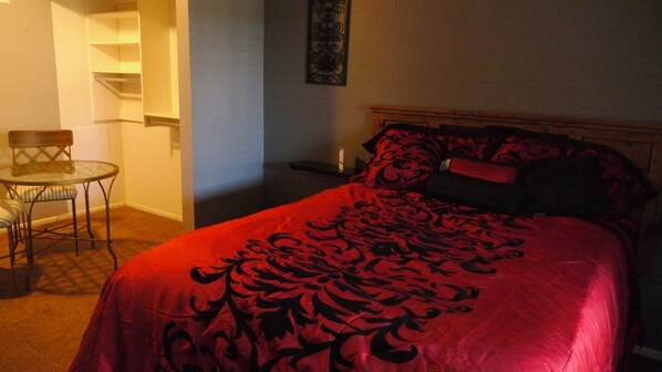 Spacious bedroom that includes queen bed and table and chairs