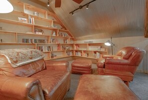 Second living area in loft with leather chairs and ottomans