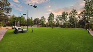 Versatile sports court with volleyball net, lounge chairs, and scenic views.