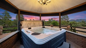 Relax in the covered hot tub while enjoying breathtaking mountain views.