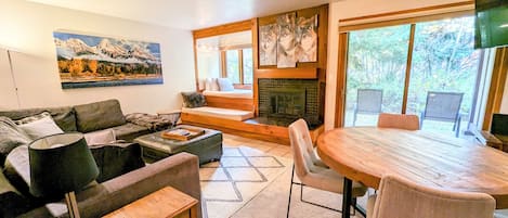 Living room and dining area looking out onto the private patio with view of window seat/daybed