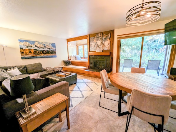 Living room and dining area looking out onto the private patio with view of window seat/daybed