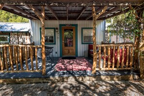 Covered front porch with table & chairs, and inviting wide benches for lounging