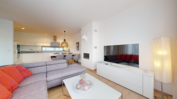 Großes Wohnzimmer mit Couchgarnitur und TV.