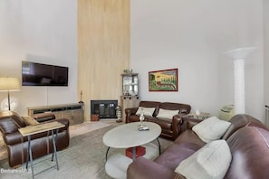 living room showing TV , fireplace and bar 