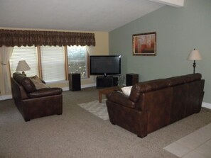 Large living room with 50 inch TV and surround sound.