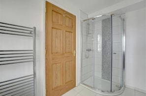 Bathroom with small dressing table behind door in front of window