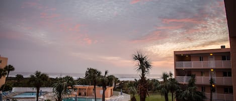 Beautiful sunset casts its rays on sky outside our window! Note view and pools!