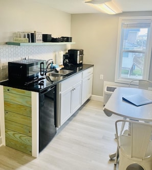 This studio condo has a small kitchenette with a mini fridge, microwave, and coffee pot.
