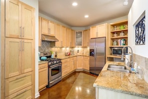 Fully stocked kitchen with modern appliances.