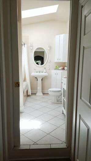 Looking into the  bathroom from the bedroom. There are 2 small steps up. 