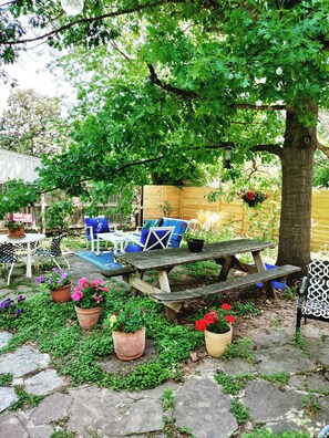 Rustic patios with plenty of seating under lush oak tree shade in afternoon.