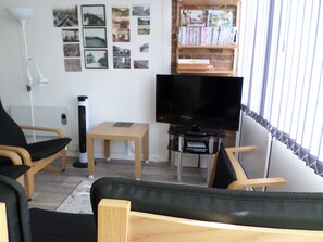 Lounge view onto TV, DVD shelf and historical photos on the wall