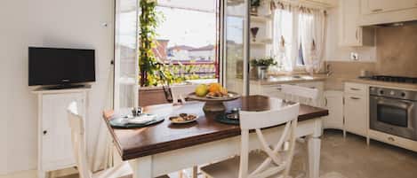 La bella e luminosa cucina con tavolo da pranzo e tv. Appartamento Ostro.