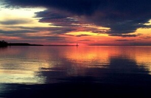 Sunset from the lake beach. Sodus Point Light house in the distance