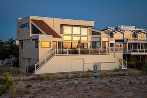 Sunrise reflected on back of house. Steps to access deck and main living area.