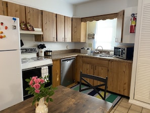 kitchen area with dishwasher, stove, refrigerator, microwave