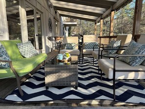 Main level deck with seating area, dining tables, bar, grill and cooler