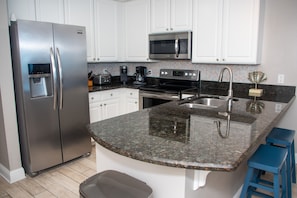 Fully Stocked Kitchen with Granite Countertops and Stainless Steel Appliances