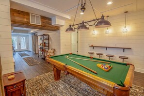 Pool table and bar seating in Lower Level Game Room