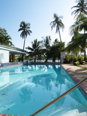 Large swimming Pool, interior patio, and leisure area with the lagoon view.