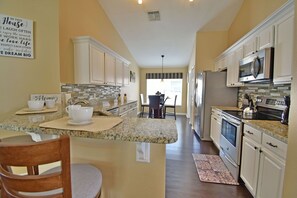 Alternative view of kitchen showing bar seating area