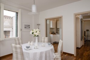 Dining room with separate kitchen in background & canal views through 3 windows