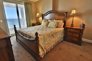 Master bedroom with a king size bed and sliding glass doors, leading to the balcony, and showing off the view!