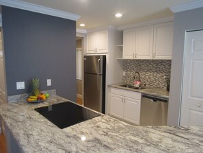 Kitchen which has a refrigerator, stove, cook top, microwave and dishwasher.