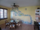 View of dining area + 4 stools Ocean visible from window Wall mural of Caribbean