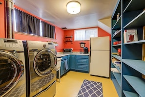 Kitchenette with open shelving, laundry, and a very groovy yellow floor! 