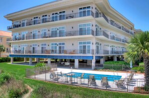 Sea Point Lodge Exterior – Pool and Building View - Exterior view of Sea Point Lodge – This gated oceanfront complex features elevator access, balconies for every unit, and a private guest-only pool just steps from the beach.