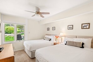 This bright and spacious bedroom features two queen beds and a flat screen TV.