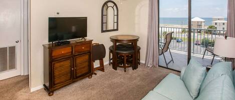 Cozy living room with a sofa sleeper, flat screen TV, and balcony access