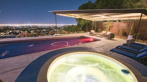 Bubbling spa w/ sun loungers overlooking the pool & city views