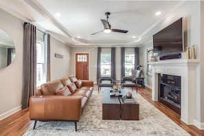 Sofa, Arm Chairs, Coffee Table, Fireplace, TV, and Ceiling Fan.