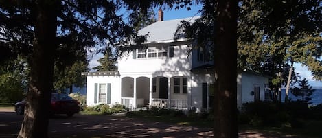 The front of the house as you drive down the tree lined driveway.