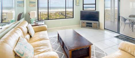 Living Room - Spacious living room with open floor plan and connected balcony featuring a direct view of the ocean.