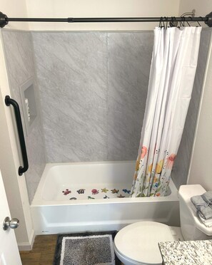 Bathroom with high shower and non-skid tub decals and grab bar