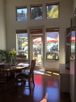 View through vaulted dining area, brightly lit with numerous windows, stunning rock gardens, patio, lawn.  Bird's paradise!