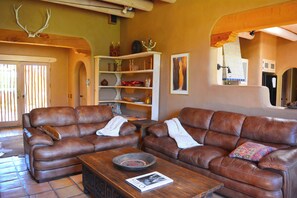 French door foyer, comfy leather sofas and view to open kitchen.